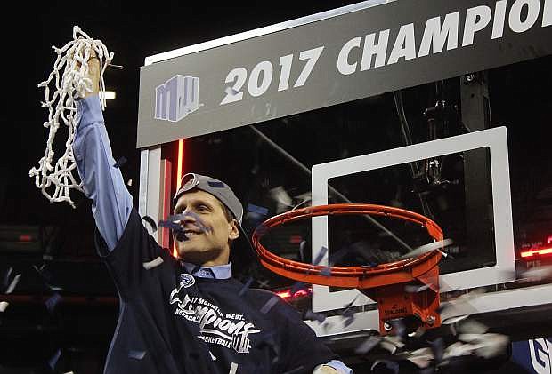 Nevada coach Eric Musselman takes down the net Saturday night in Las Vegas after the Pack defeated Colorado State.