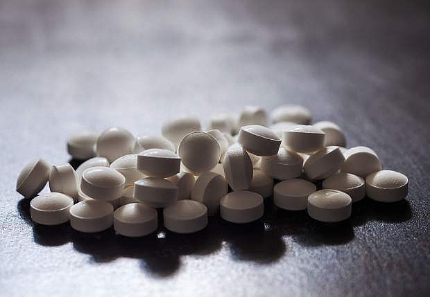 Backlit white pills - Opioid and prescription medication addiction epidemic or crisis - concept