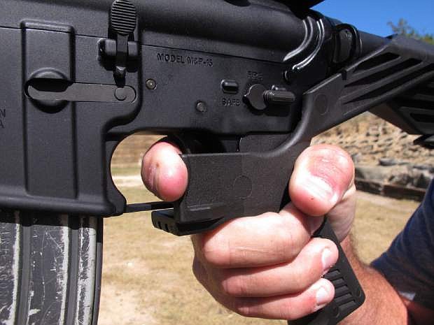 Shooting instructor Frankie McRae demonstrates the grip on an AR-15 rifle fitted with a bump stock at his 37 PSR Gun Club in Bunnlevel, N.C., on Oct. 4.