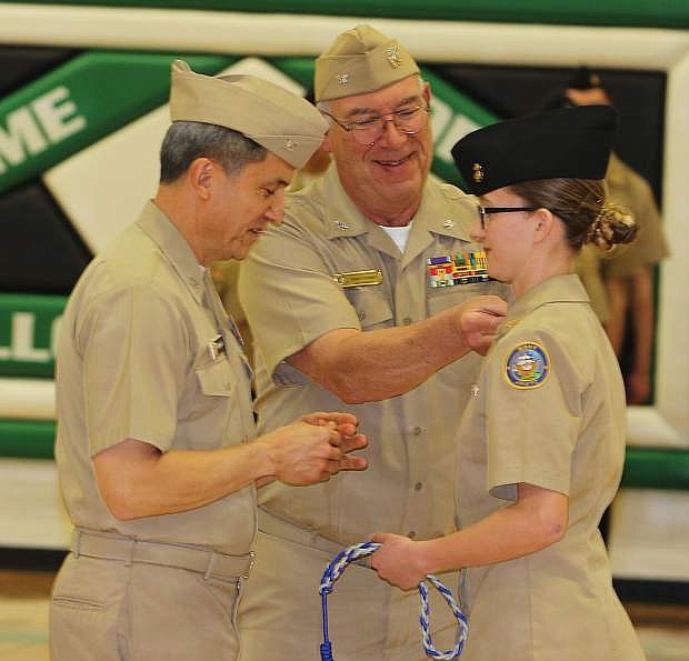 Retired Navy Capt. Wenceslao, left, and Retired Capt. Robert Kerman present an award to Taylor DeBrum.