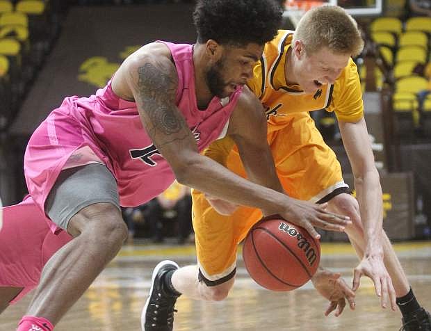 Nevada forward Elijah Foster (12) and Wyoming forward Hayden Dalton (20) scramble for the ball during the first half of an NCAA college basketball game in Laramie, Wyo., Wednesday, Jan. 24, 2018. (Shannon Broderick/Laramie Boomerang via AP)
