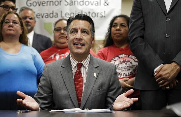 FILE - In this June 15, 2017, file photo, Nevada Gov. Brian Sandoval speaks before signing Senate Bill 539 during a signing ceremony in North Las Vegas, Nev. State officials and medical administrators are starting a new prescription medication registry early January 2018 designed to fast-track information collection about opioid deaths and identify excess dispensing of powerful painkillers. The effort enacts provisions of Assembly Bill 474, which was proposed by Sandoval and unanimously passed the Legislature this year. (AP Photo/John Locher, File)
