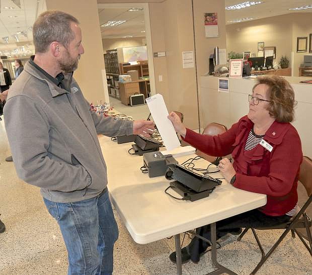 Supervisor Brad Bonkowski checks in for early voting with Deputy Clerk Beth Phelps Thursday at the County Courthouse.