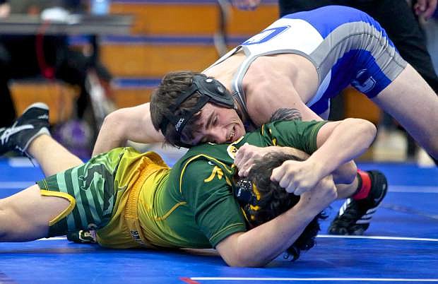 Carson&#039;s Bryce Newhall grapples with a Manogue wrestler on Saturday at regionals.