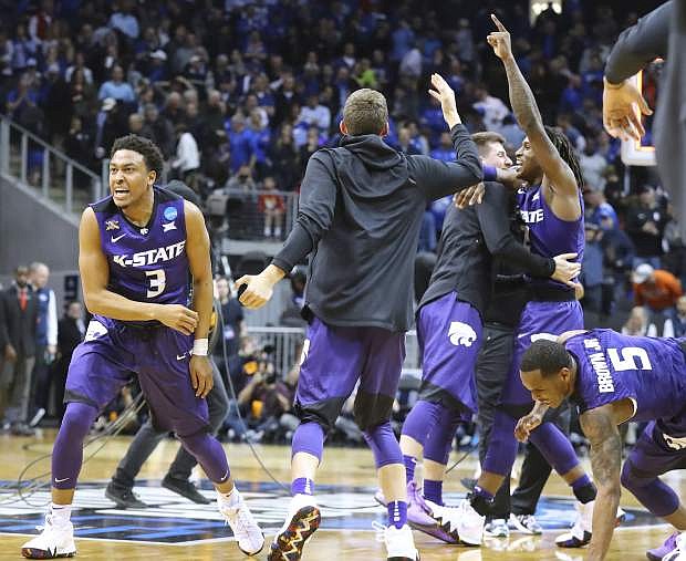 Kansas State guard Kamau Stokes and teammates celebrate after defeating Kentucky, 61-58, in Thursday&#039;s South Region semifinal.