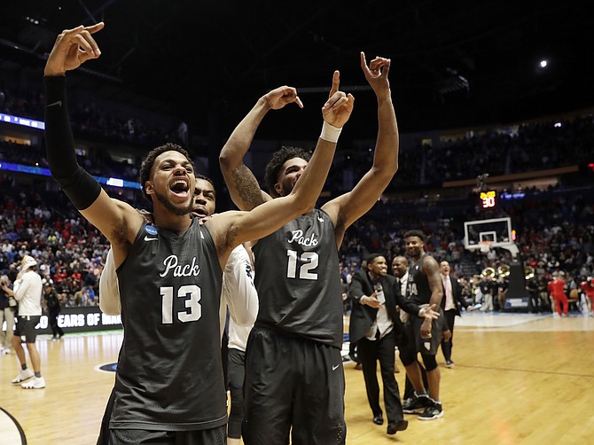 Nevada guard Hallice Cooke (13) and forward Elijah Foster (12) celebrate at the end end of the second half of a second-round game against Cincinnati, in the NCAA college basketball tournament in Nashville, Tenn., Sunday, March 18, 2018. Nevada defeated Cincinnati 75-73. (AP Photo/Mark Humphrey)