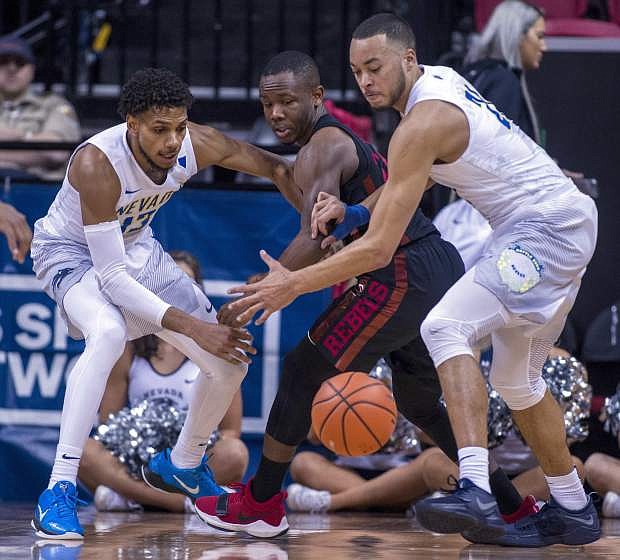 UNLV guard Jordan Johnson (24) looks to a loose ball between Nevada guard Hallice Cooke (13) and guard Kendall Stephens (21) during the first half of an NCAA college basketball quarterfinals game in the Mountain West Conference tournament Thursday, March 8, 2018, in Las Vegas. (AP Photo/L.E. Baskow)