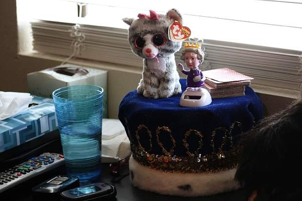 Dilley, who said he is related to royalty, displays his crown and Queen Elizabeth bobblehead given to him by his daughter.