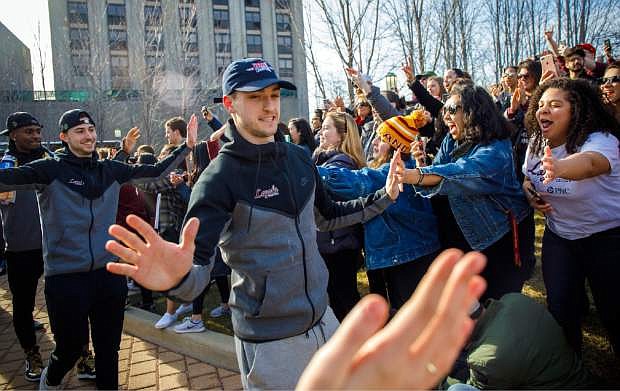 Loyola guard Clayton Custer and teammates greet fans as they welcome the Ramblers back to campus on Sunday, March 18, 2018, in Chicago, after the team advanced to the Sweet 16 of the NCAA Tournament in their first appearance since 1985. (Brian Cassella/Chicago Tribune via AP)