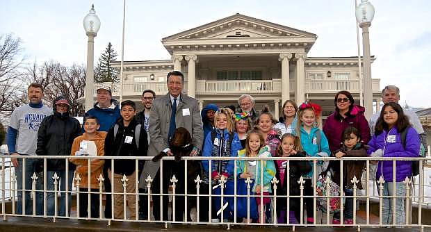 Governor Brian Sandoval and his puppy &#039;Charley&#039; pose for a photo with Bordewich-Bray students and NDOT employees in front of the Governor&#039;s Mansion Wednesday on Nevada Moves Day.