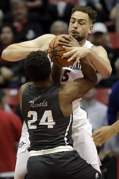 San Diego State&#039;s Kameron Rooks blocks a shot by Nevada&#039;s Jordan Caroline in the first half Saturday.