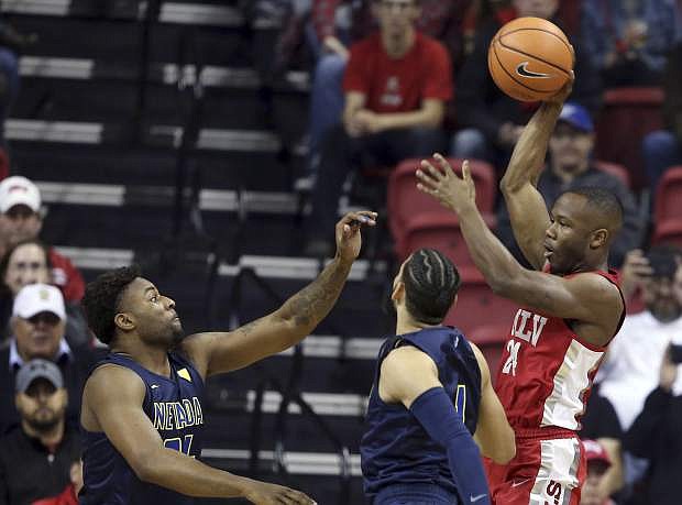 UNLV&#039;s Jordan Johnson (24) passes the ball over Nevada&#039;s Jordan Caroline, left, and Cody Martin on Feb. 28. UNLV beat Air Force on Wednesday in the Mountain West tournament, setting up a Thursday rematch with the Wolf Pack.