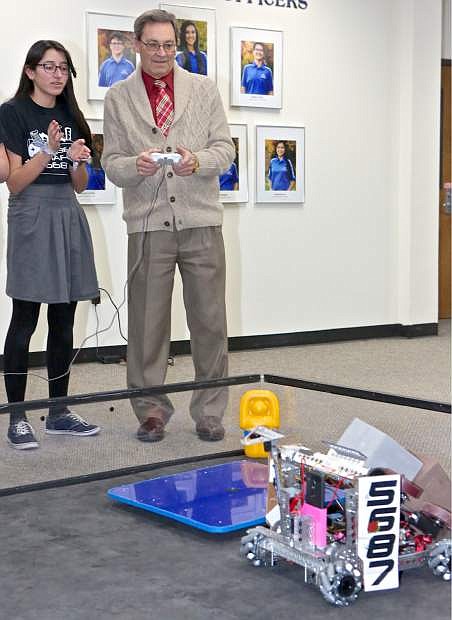 Sarai Jauregui-Rivas, 14, of the CHS Robotics Team gives Carson City School Superintendent Richard Stokes a lesson on how to drive one of the team&#039;s robots Wednesday night at the high school.