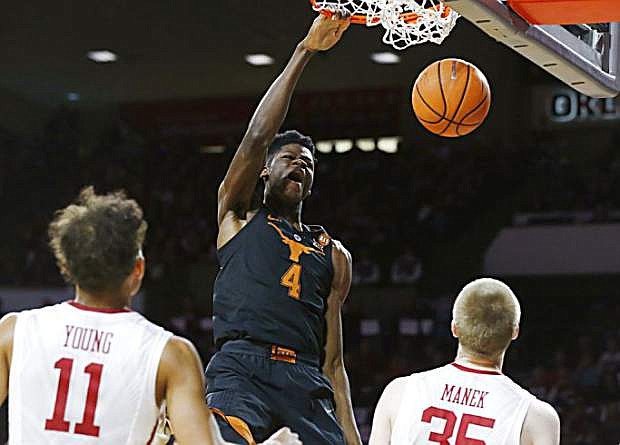 FILE - In this Feb. 17, 2018, file photo, Texas forward Mohamed Bamba (4) dunks in front of Oklahoma guard Trae Young (11) and forward Brady Manek (35) in the first half of an NCAA college basketball game, in Norman, Okla. Bamba was named to the AP All-Big 12 team, Tuesday, March 6, 2018. (AP Photo/Sue Ogrocki, File)