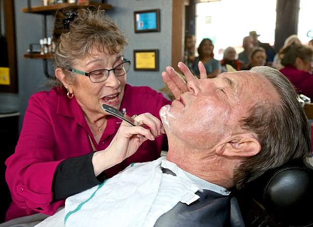 Maria Cipriani gives Mayor Bob Crowell a shave Wednesday evening at the grand opening of Cipriani&#039;s Barber Shop on Carson St.