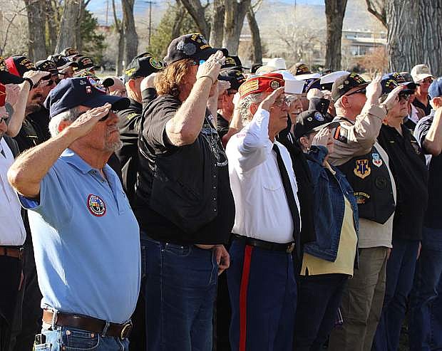 Vietnam veterans salute during the playing of Taps, which was performed by the Nevada Veterans Coaliton.