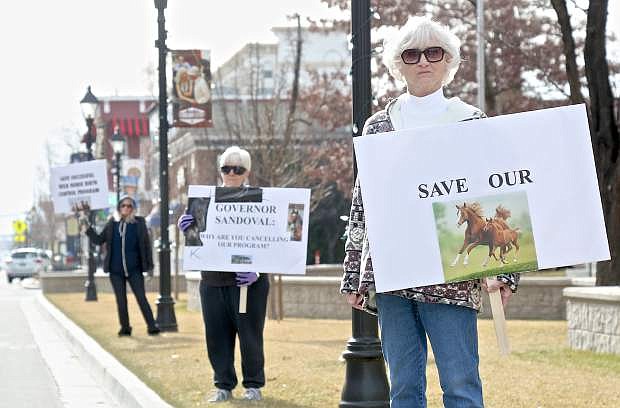 Julie Lee and Rae Hanna of Dayton and Sue Olmsted of Stagecoach protest in front of the State Capitol Wednesday morning.