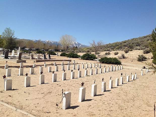 The grave markers of Civil War veterans to the west of the Civil War Veterans Monument. Slide Mountain is in the background towering over Washoe Valley.