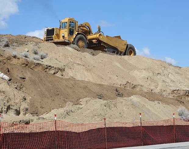 An earth mover grades a hillside for the Carson Hills Apartment complex that is under construction behind the Casino Fandango.