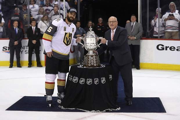 Vegas Golden Knights&#039; Deryk Engelland (5) accepts the Clarence S. Campbell Bowl from Deputy Commissioner Bill Daly after defeating the Winnipeg Jets during Western Conference Finals, game 5, in Winnipeg, Sunday, May 20, 2018. (Trevor Hagan/The Canadian Press via AP)