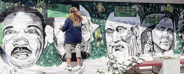 Diana Uzzell paints a mural at Pioneer High School.