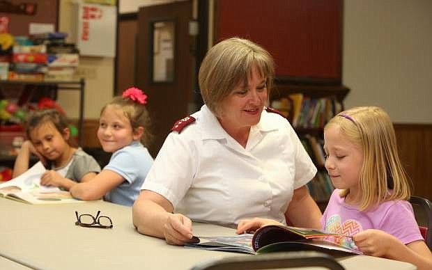 Capt. Leslie Cyr tutors 7-year-old Sadie Brockway during the Salvation Army&#039;s after school program.
