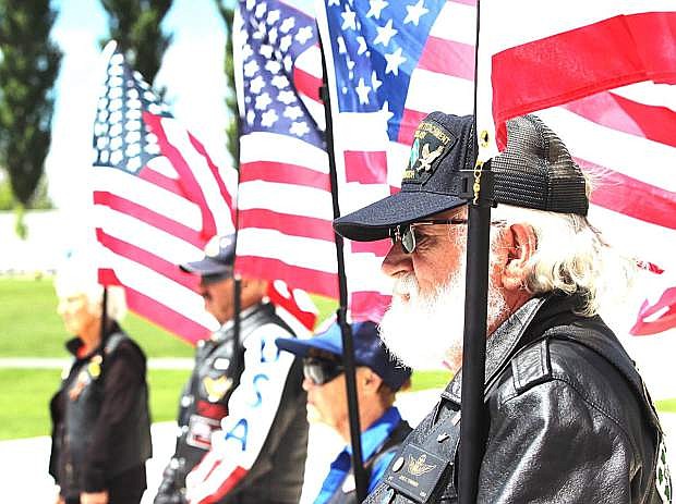 Patriot Guard riders hold U.S. flags during the military service.