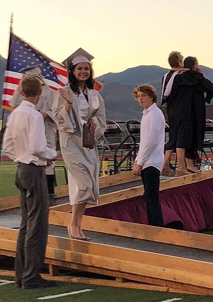 Dayton High graduate Amanda Acosta waves to her family after receiving her diploma on Wednesday night.