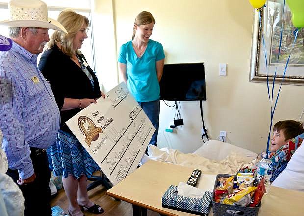 Reno Rodeo Association President Bill Summy and Clara Andriola, Executive Director, present William Strange, 10, a check for $6,500 Thursday at the Carson-Tahoe Hospital&#039;s Cancer Treatment Center. Also pictured is William&#039;s mother Lora Strange.