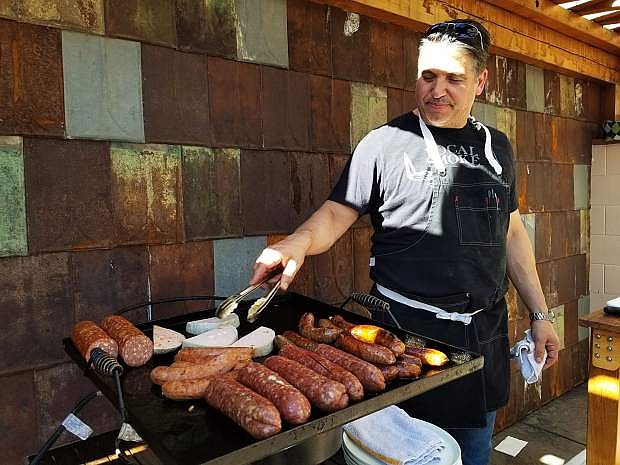 Chef and owner Mark Estee barbecues sausage for The Union&#039;s one-year anniversary celebration.