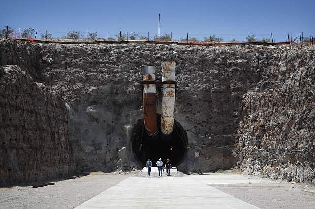 People leave the south portal of Yucca Mountain during a congressional tour Saturday, July 14, 2018, near Mercury, Nev. Several members of Congress toured the proposed radioactive waste dump 90 miles northwest of Las Vegas. (AP Photo/John Locher)