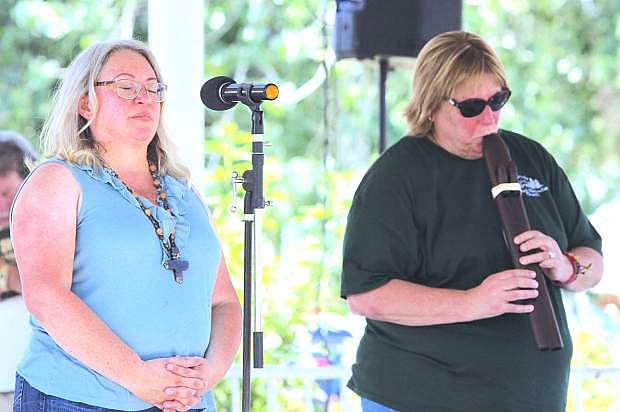 Pastor Dan Blundell, left, of Epworth Methodist Church, closes her eyes as Becky Stockdale plays the flute.