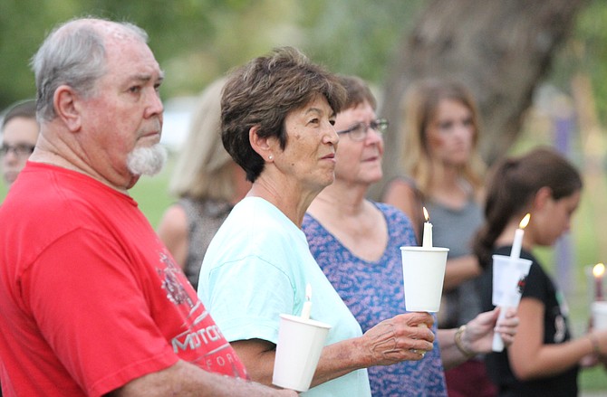 Community members attend a candlelight vigil Monday night for a fallen firefighter who was fatally shot Sunday.