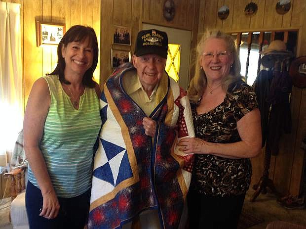 Nancy Bell, left, and Marsha Strand, right, with Pearl Harbor attack survivor, Bob Lloyd, in his Dayton home on Aug. 1.
