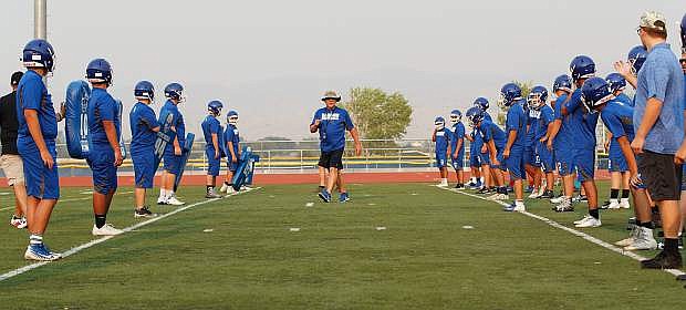 Coach Roman pumps up the team for a drill during the season opening football practice at Carson High School, Carson City, NV