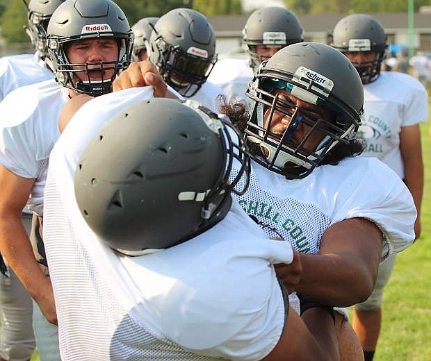 Sione Otuafi, right, takes part in football practice last week. The Greenwave hosts a scrimmage Friday night against Lassen and then opens the season next week against Spring Creek.