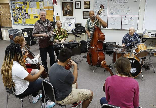 Members of a Carson High School orchestra class play music with Blood Drum Spirit in Carson City, Nev., on Tuesday, Aug. 21, 2018. The group, featuring sounds and instruments from Ghana, West Africa will be performing as part of the weekend Jukebox International Film Festival.