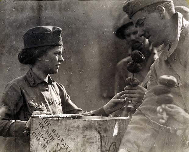 A Salvation Army Doughnut girl serves an American GI during World War I in France.