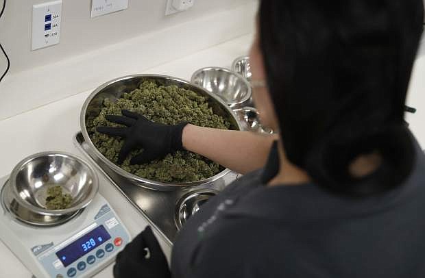 In this Aug. 1, 2018, photo, Christine Glenn sorts marijuana at the Blum marijuana dispensary in Las Vegas. Nevada regulators and industry insiders say the state&#039;s first year of adult-use marijuana sales has exceeded their expectations. (AP Photo/John Locher)