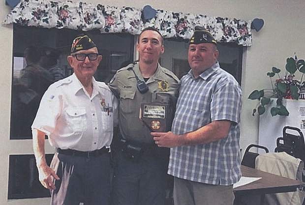 Veterans of Foreign War Post 8660 members John Alexander, left, and Ken Gray, right, present an award of appreciation to Deputy Nathan Cooper.