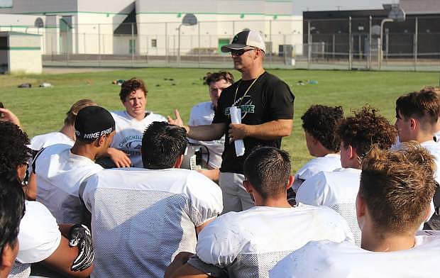 Coach Brooke Hill talks to his team after practice. The Greenwave football team opens the season tonight (Aug. 24) at the Edward Arciniega Athletic Complex.
