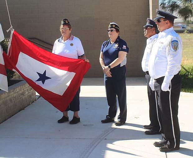 From left, Valerie Schevering, 4th District commander of the American Legion; Patricia Brown, commander of American Legion Post 37 of Fernley; and Nevada Veterans Coalition members Robert Roman and Rick Rose prepare to raise the Blue and Gold Star flags.