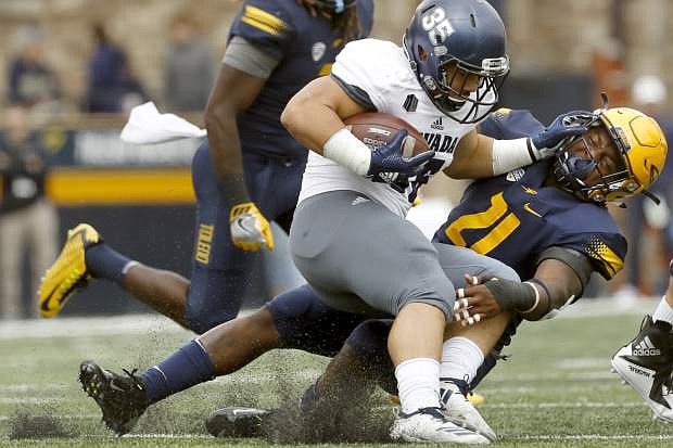 Nevada&#039;s Toa Taua (35) attempts to fend off Toledo&#039;s DeDarallo Blue (21) during the first half of an NCAA college football game Saturday, Sept. 22, 2018, in Toledo, Ohio. (Katie Rausch/The Blade via AP)