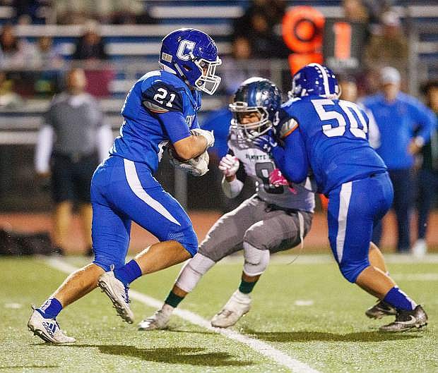 Bradley Maffei carries the ball through the line with a block from CJ Linkul during Friday&#039;s game against Damonte Ranch.