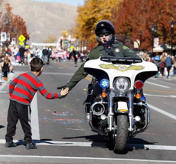 A Carson City Sheriff&#039;s Department Motor Patrol gets a high five during the 2017 Nevada Day Parade, Carson City, NV