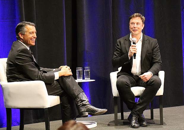 Gov. Brian Sandoval, left, and Tesla CEO Elon Musk share a laugh during a discussion at a technology and innovation summit at the Tesla Gigafactory inside the Tahoe-Reno Industrial Center on Tuesday, Oct. 9, 2018.