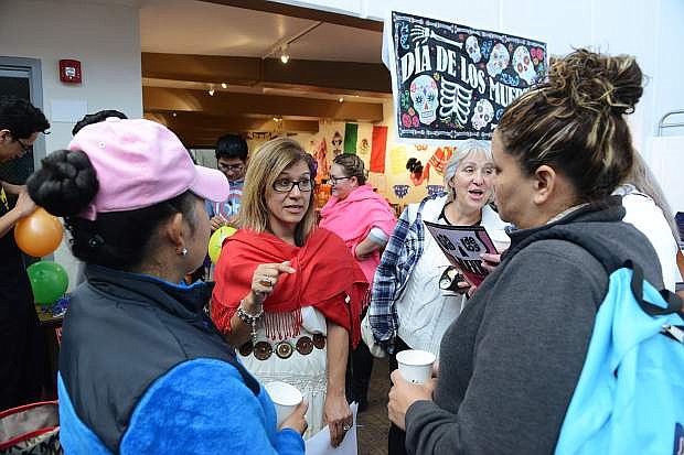 Latino Outreach Coordinator Lupe Ramirez, center, talks with guests at the Dia de los Muertos (Day of the Dead) celebration at Western Nevada College on Nov.1, 2017.
