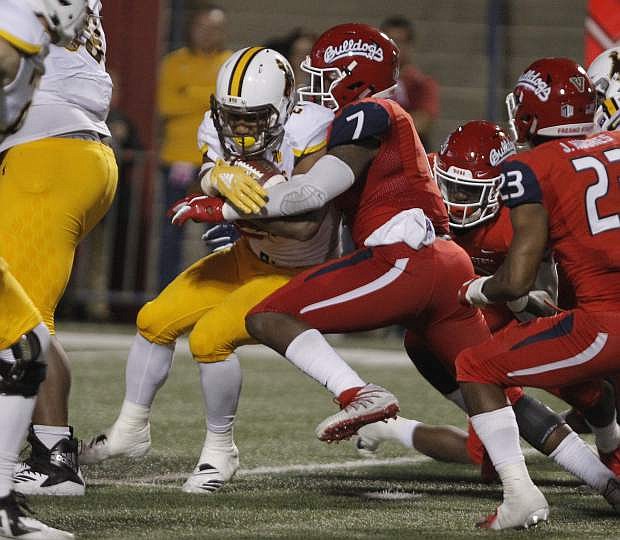 Wyoming running back Nico Evans is bottled up by Fresno State linebacker James Bailey on Saturday in Fresno, Calif. Fresno State beat Wyoming, 27-3.