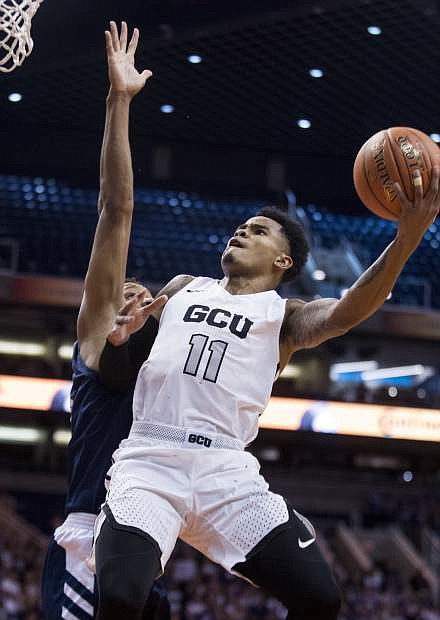 Grand Canyon&#039;s Carlos Johnson (11) drives to the basket against Nevada&#039;s Tre&#039;Shawn Thurman (0) during the first half of an NCAA college basketball game Sunday, Dec. 9, 2018, in Phoenix. (AP Photo/Darryl Webb)