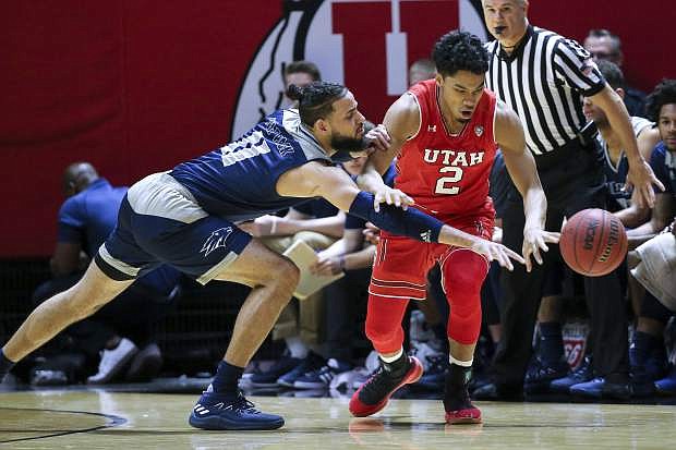 Nevada forward Cody Martin (11) tries to steal the ball from Utah guard Sedrick Barefield (2) during the first half Saturday in Salt Lake City.